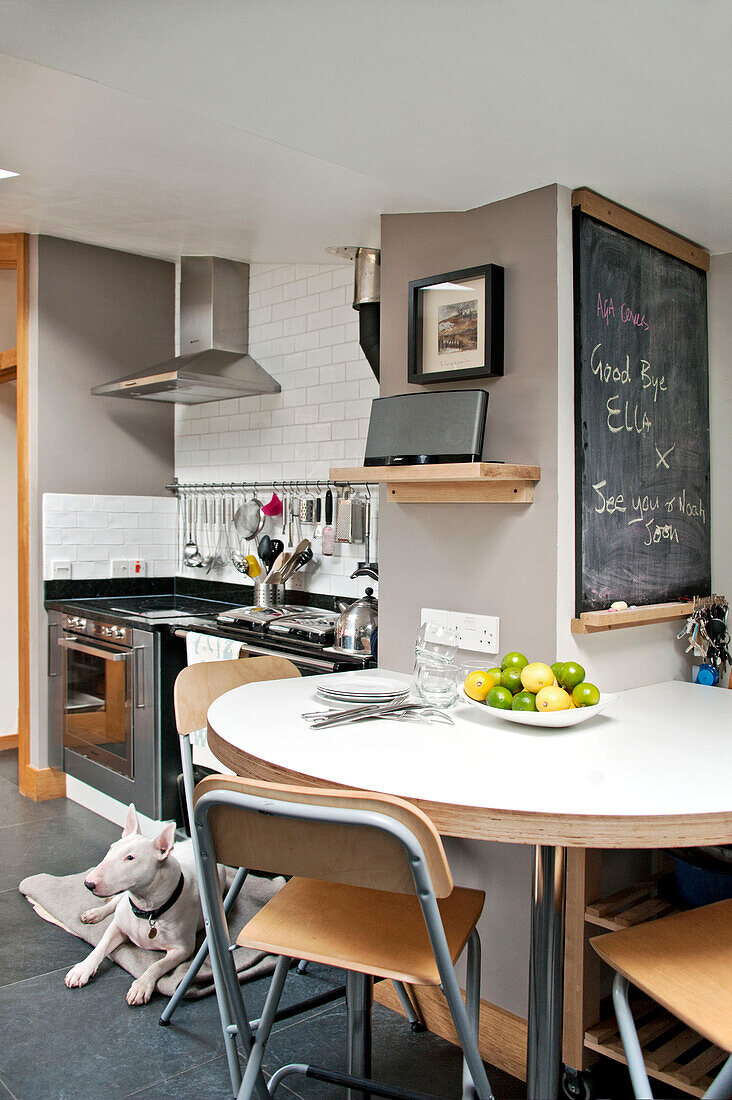 Klappstühle am Tisch in einer modernen Küche mit Tafel in einem Haus in Cornwall, UK