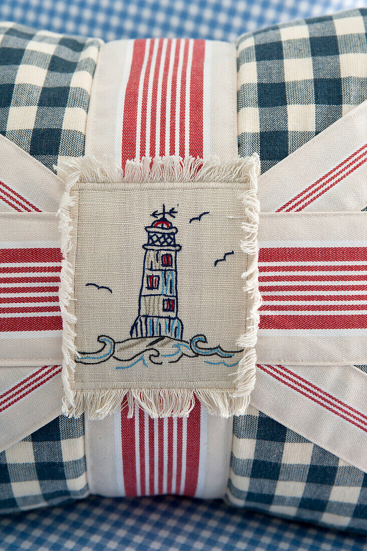 Lighthouse on Union Jack cushion stitched with striped and checked fabric, Cornwall, UK