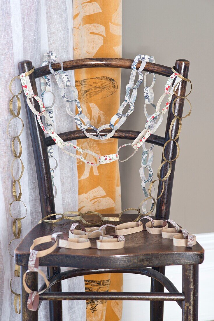 Paper chains on wooden chair in London home England UK