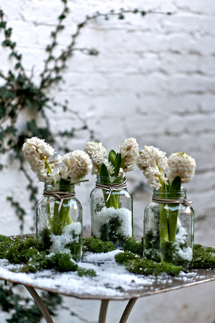 Cut flowers in jam jars in London courtyard England UK