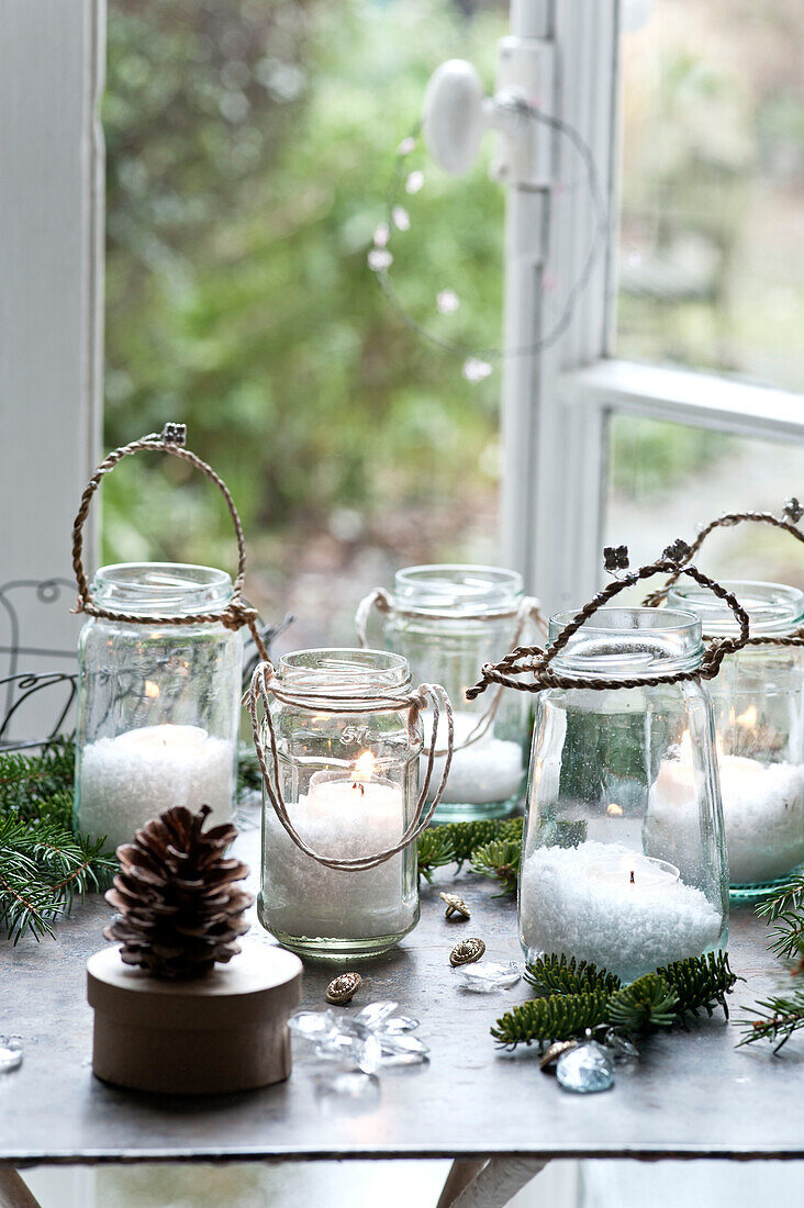 Table filled with glowing jam jar lanterns