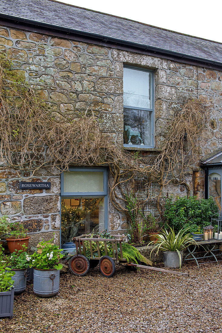 Gartenkarre auf Schotterweg am Fenster des Hauses in Penzance, Cornwall UK