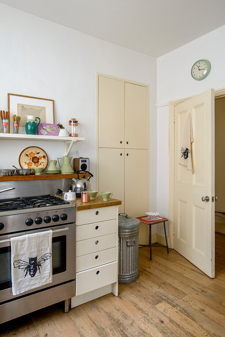 Stainless steel oven and cupboard storage in retro style London kitchen UK