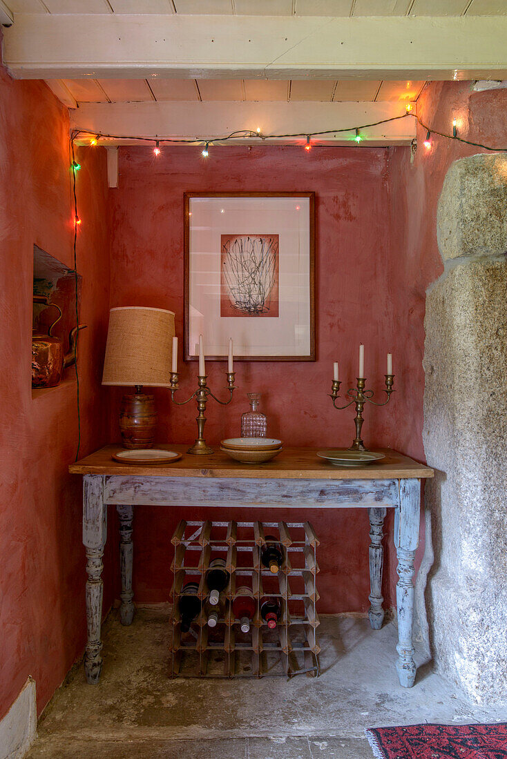 Candlesticks on table with wine rack and fairylights in Helston farmhouse Cornwall UK