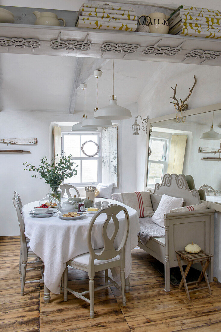 Dining table and chairs with large mirror in Marazion beach house Cornwall UK