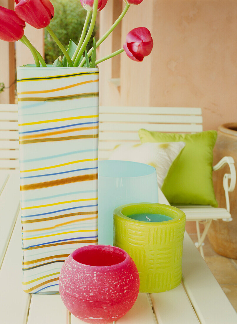 Gartentisch mit Kerzen und Blumenvase auf der Terrasse