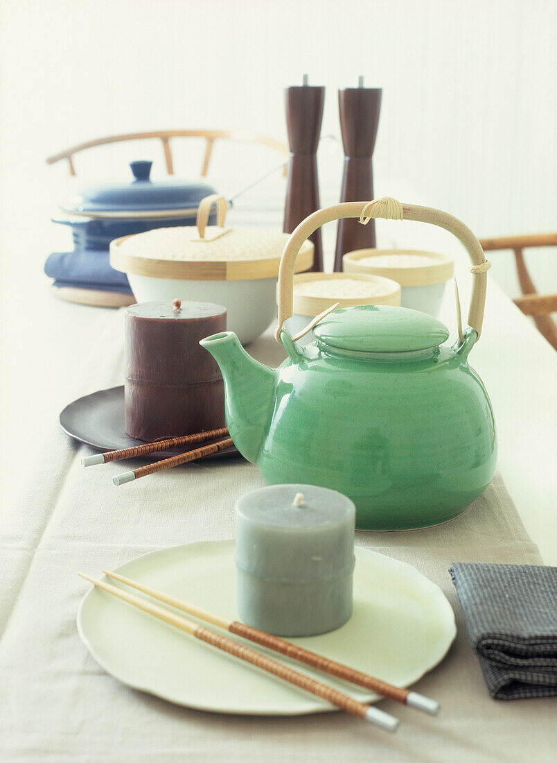 Orientalisch gedeckter Tisch mit Kerzen, Teekanne und Essstäbchen