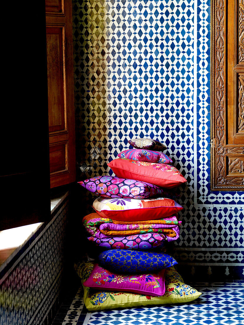 Bright cushions and geometric tiling in Moroccan riad North Africa