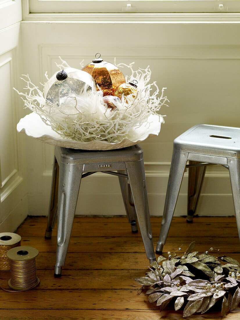 Glass baubles on stool with wreath and gold string