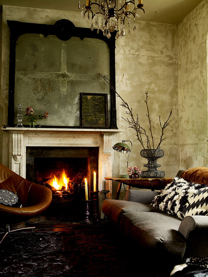 Retro furniture and lit fire with salvaged mirror frame