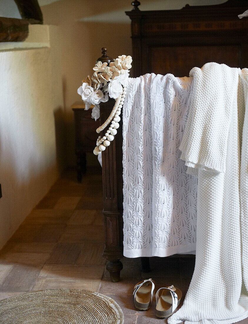 White lace and floral accessories and necklaces on vintage bed in Sicilian home