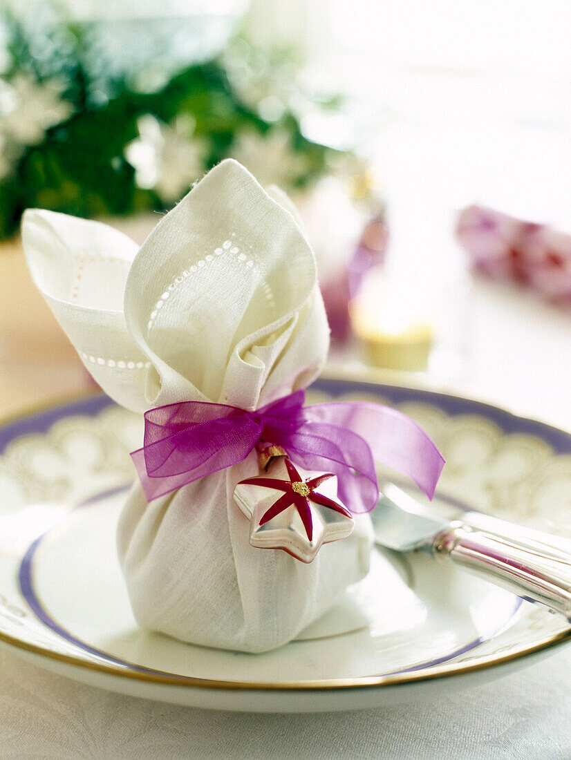 Linen napkin tied with pink ribbon and bauble decoration