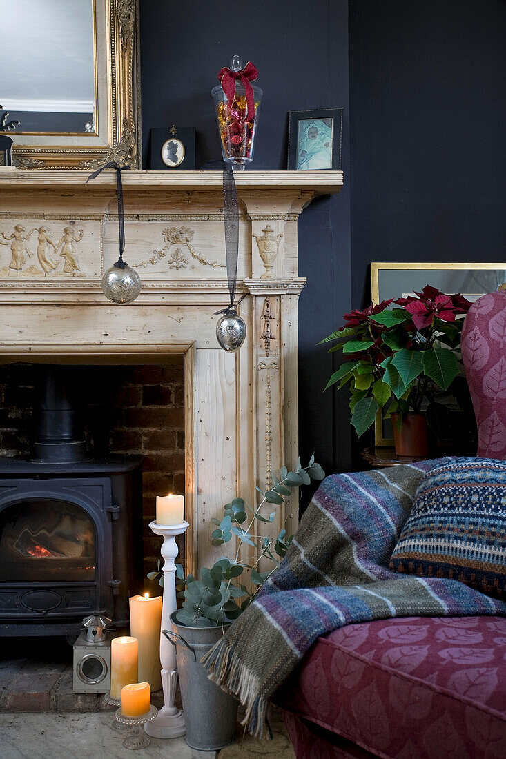 Lit candles in fireplace with woodburning stove in living room of Tenterden family home, Kent, England, UK