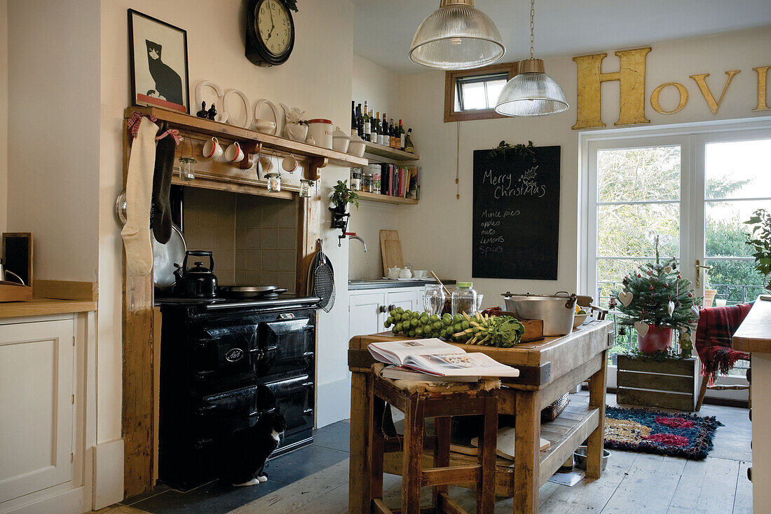 Recipe book and ingredients with pan on butchers block in Tenterden kitchen, Kent, England, UK