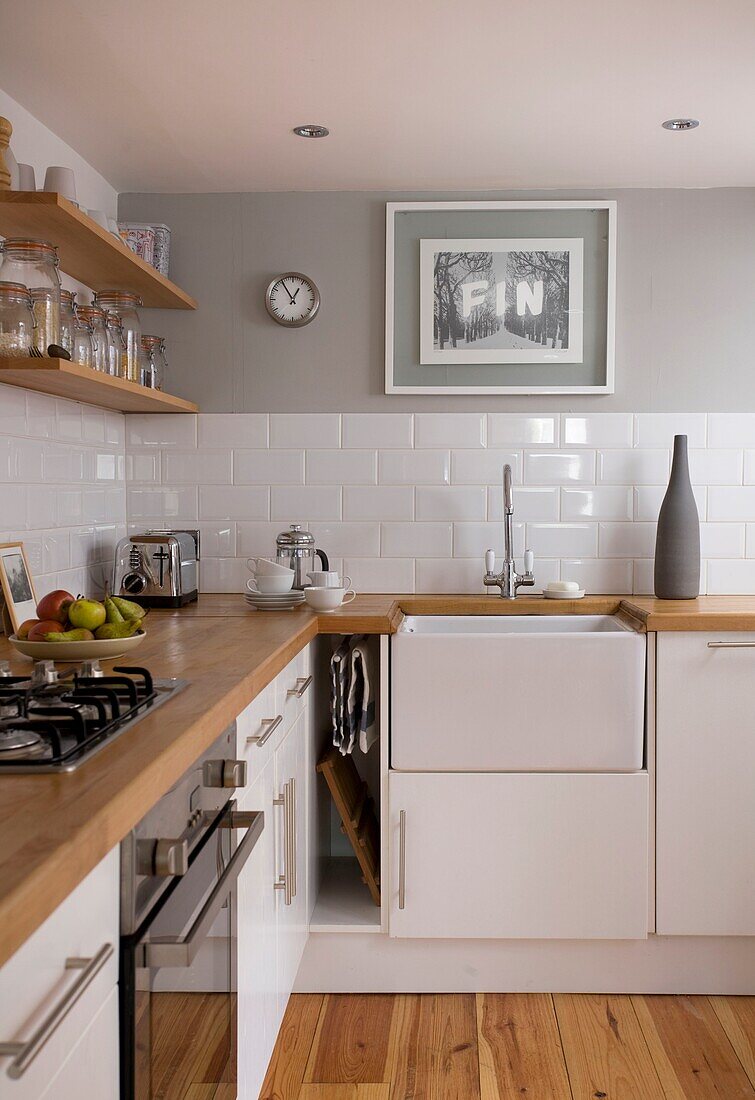 Wooden shelving in light grey and white kitchen in St Leonards home, East Sussex, England, UK