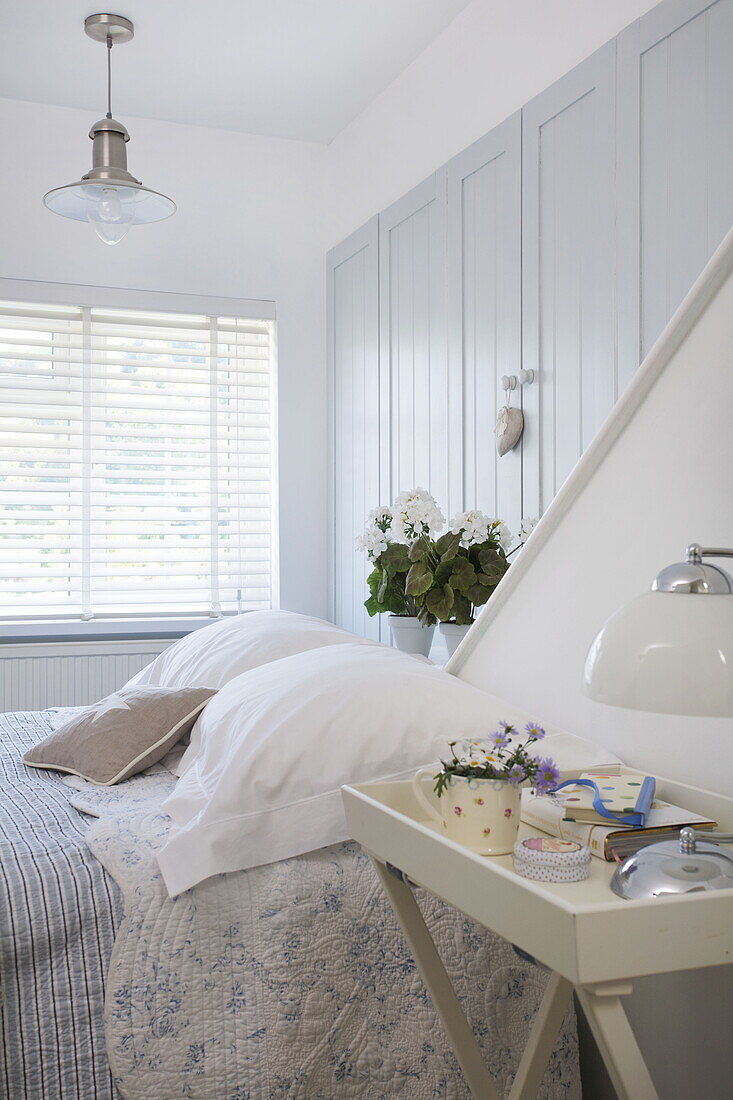 Light blue built-in cupboards above double bed in Dartmouth beach house, Devon, UK