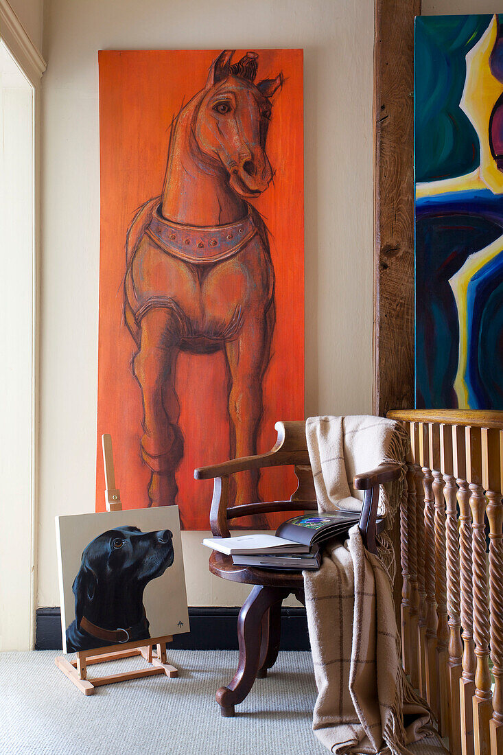 Großes Kunstwerk auf Leinwand mit Holzstuhl auf dem Treppenabsatz in einem Bauernhaus in Etchingham, East Sussex, England, UK