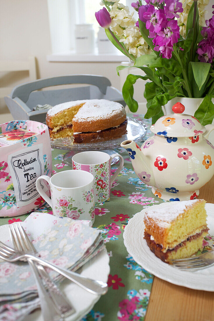 Victoria-Biskuitkuchen und Teekanne auf dem Küchentisch in einem Bauernhaus in High Halden (Kent, England)