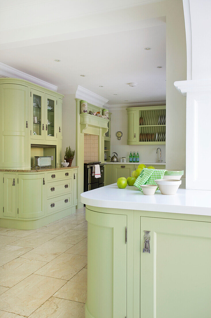 Light green open plan kitchen in Kent home England UK