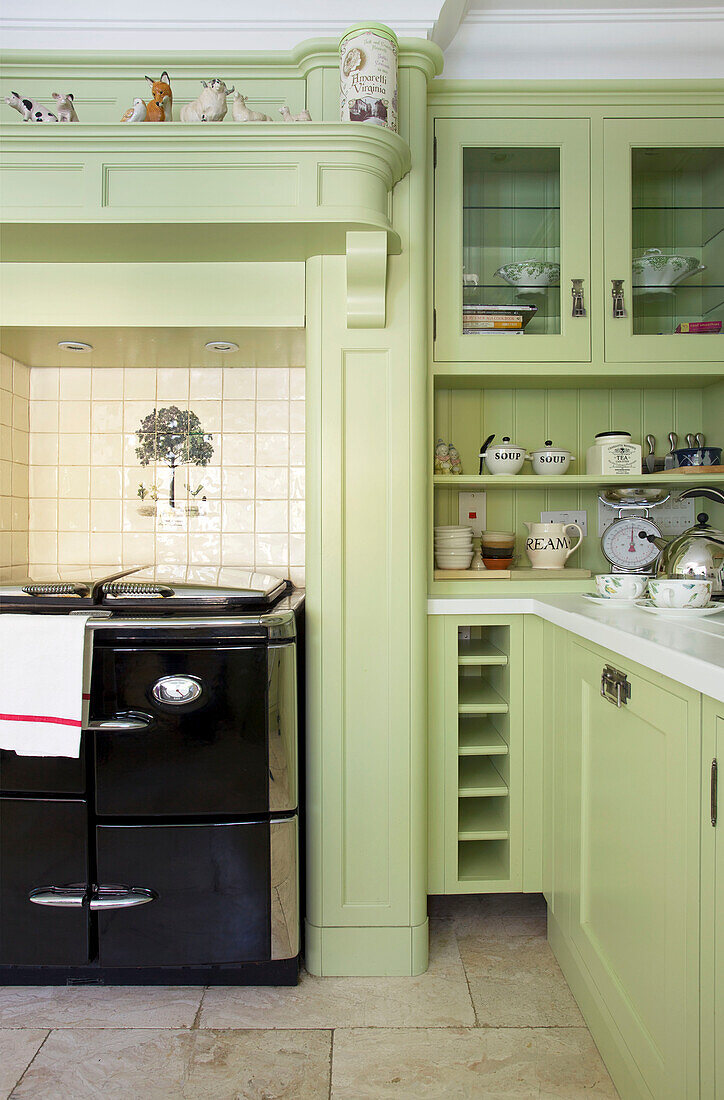 Black range oven in light green fitted kitchen Kent home England UK