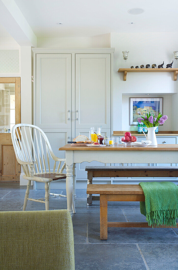 Painted white chair at table in open plan kitchen of Woodchurch home Kent England UK