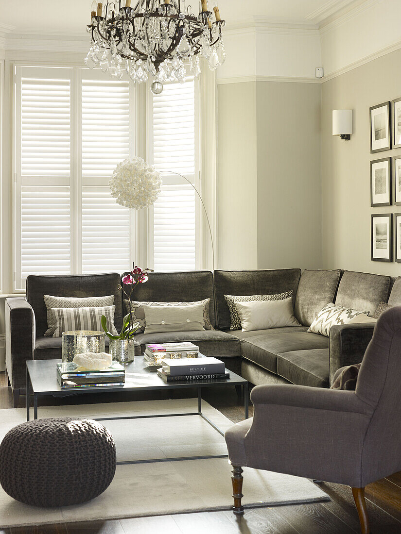 Graues Ecksofa mit quadratischem Couchtisch und Korbhocker in einem Londoner Haus England UK