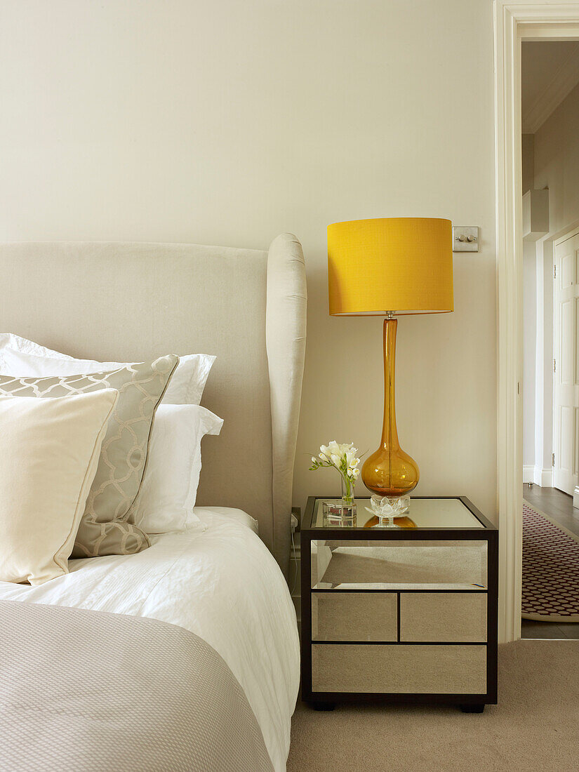 Yellow lampshade on mirrored cabinet Little Venice townhouse London England UK