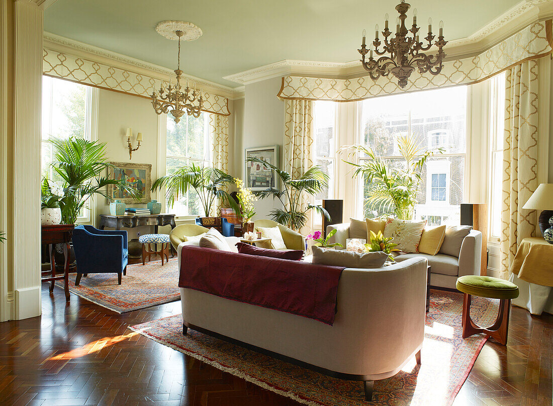 Houseplants and seating in large drawing room of London townhouse apartment, UK