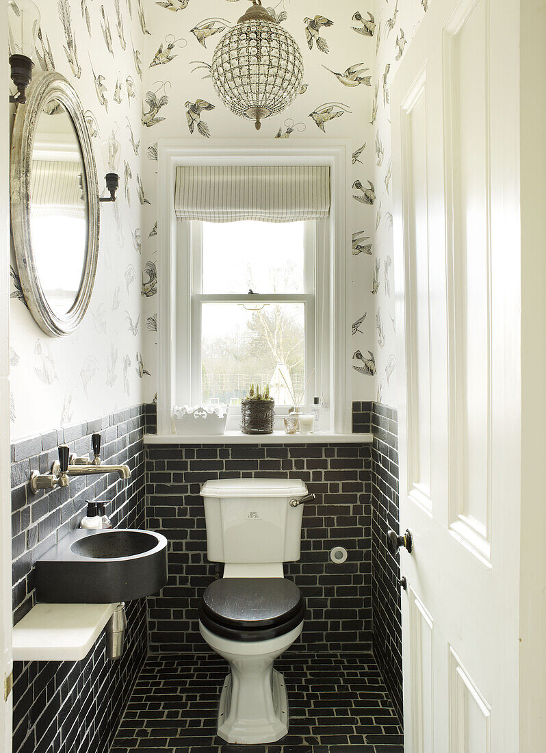 Schwarz-weißes Badezimmer mit silbergerahmtem Spiegel in einem Landhaus in East Sussex, England, UK
