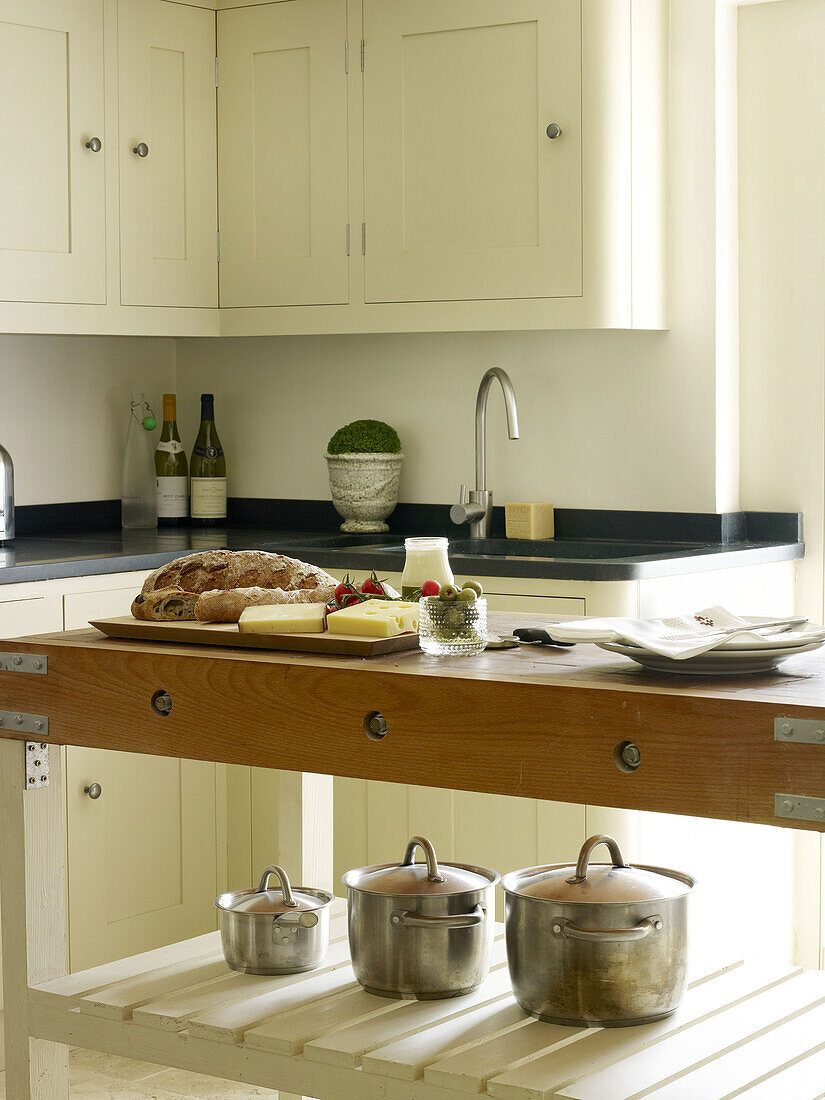 Bread and cheese on butchers block in North London kitchen England UK