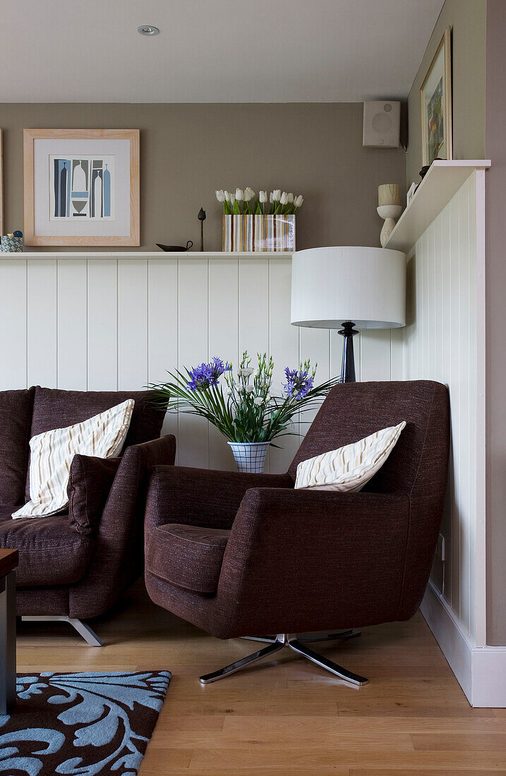 Brown armchair and sofa in panelled living room of Cambridgeshire home UK