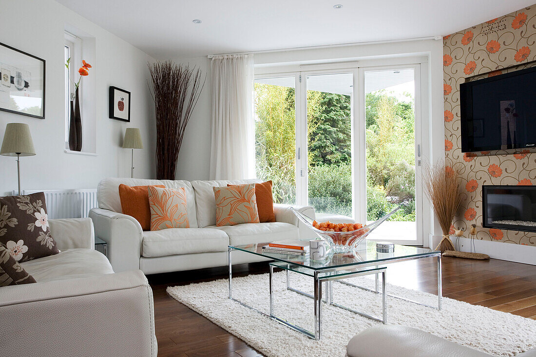 Couchtische mit Glasplatte in einem Wohnzimmer in Cambridgeshire mit Plasmabildschirm an einer Wand UK