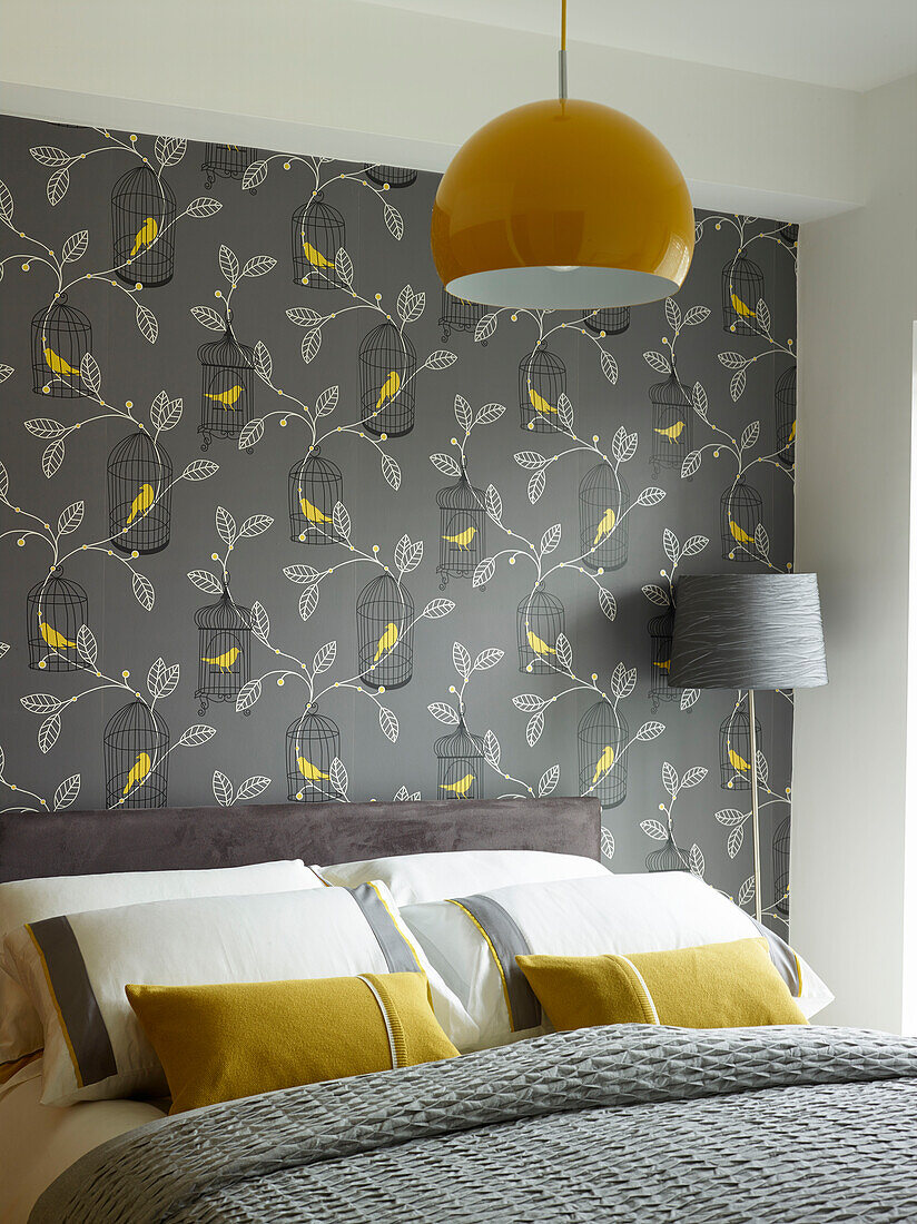 Graues und gelbes Schlafzimmer mit Vogel- und Blattmustertapete in einem Haus in Manchester, England, Vereinigtes Königreich