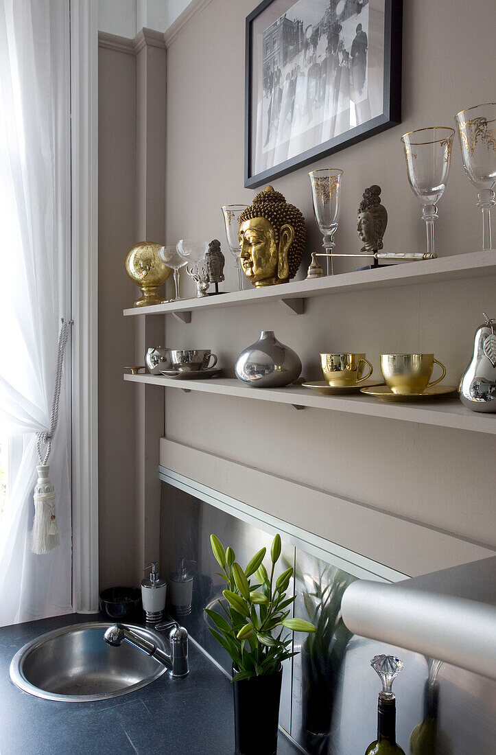 Gold and silver ornaments on shelf above sink in Hove home East Sussex UK