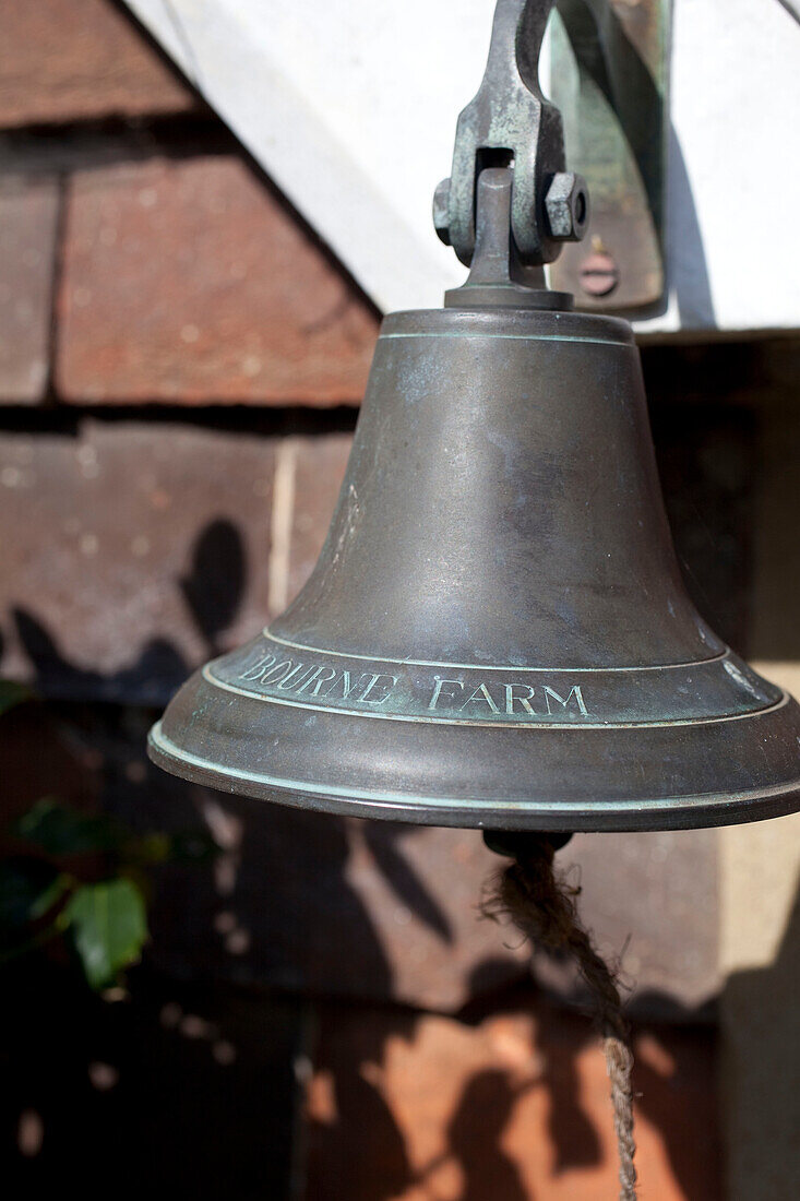 Antique bell hangs outside Kent country cottage, England, UK
