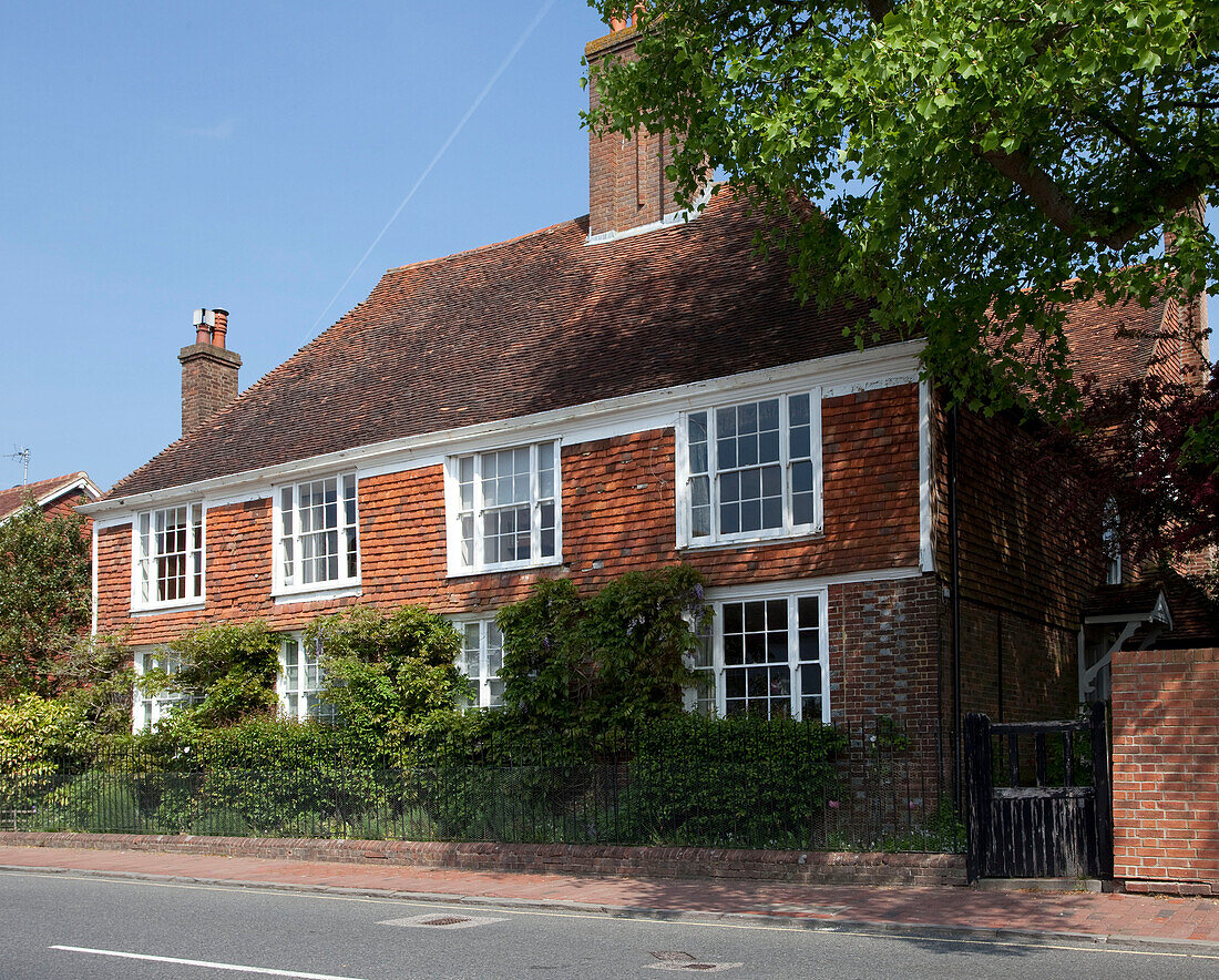 Brick exterior with tiled roof and chimney of East Sussex home, England, UK