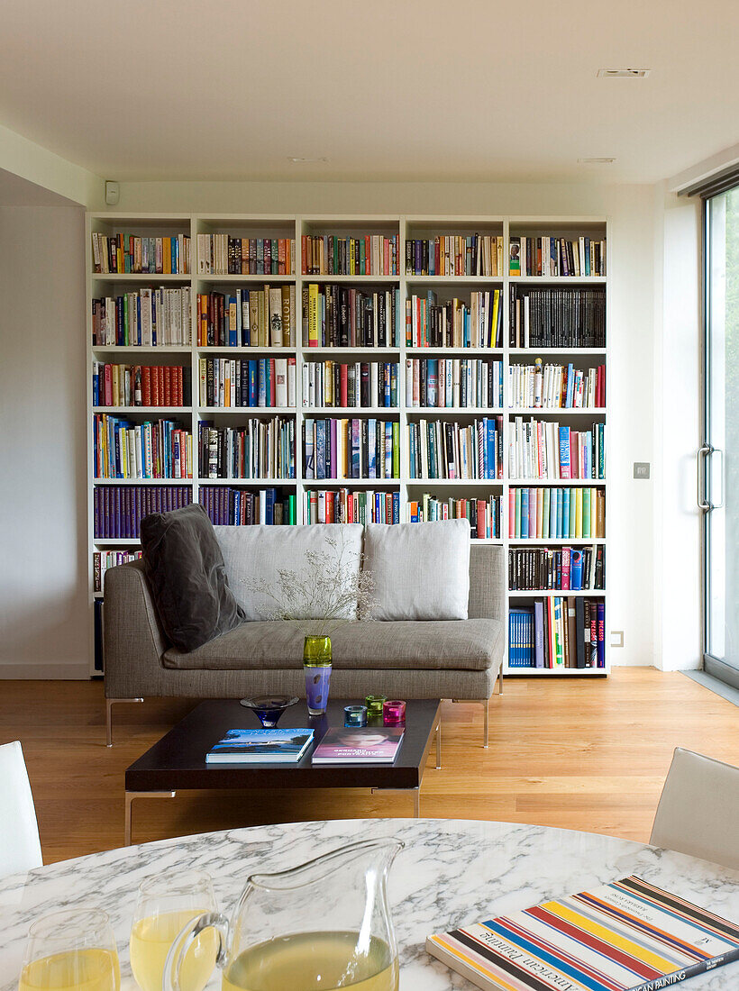 Extensive reference library and two seater sofa in London home, England, UK