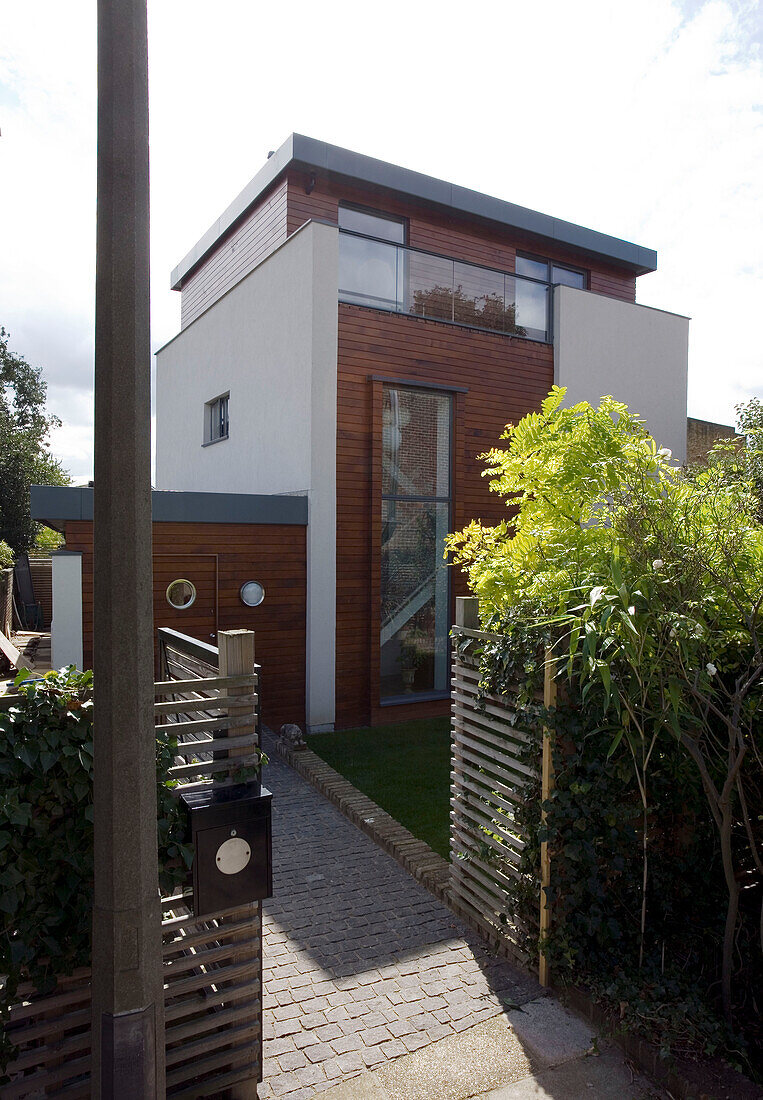 Gateway entrance to newbuild with wood cladding, London, England, UK