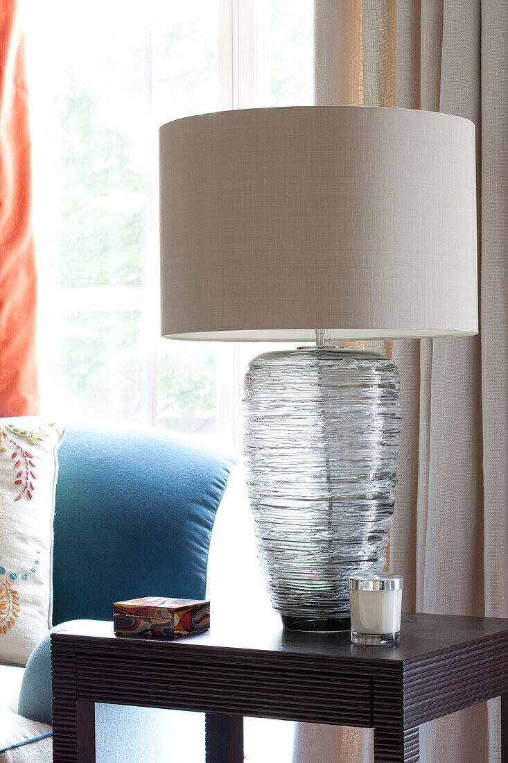 Glass lamp on side table in contemporary London home, UK