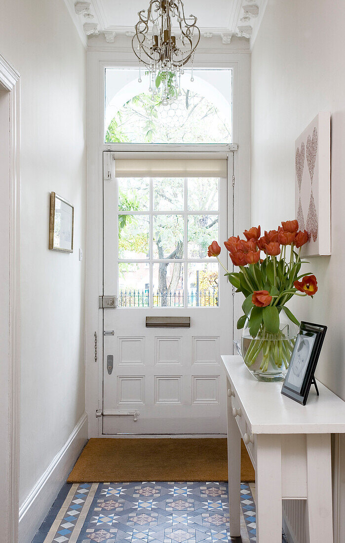 Cut tulips on console of tiled London hallway UK