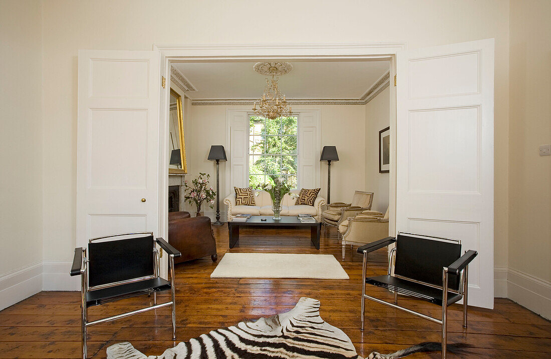Zebra print rug and matching black leather chairs in double reception room of townhouse