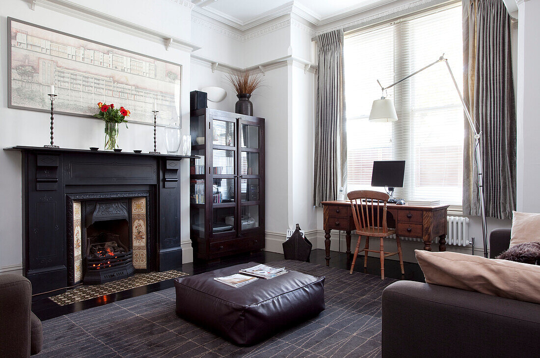 Großer Kamin im modernen Wohnzimmer eines Hauses in Hove mit Schreibtisch am Fenster, East Sussex, England, UK