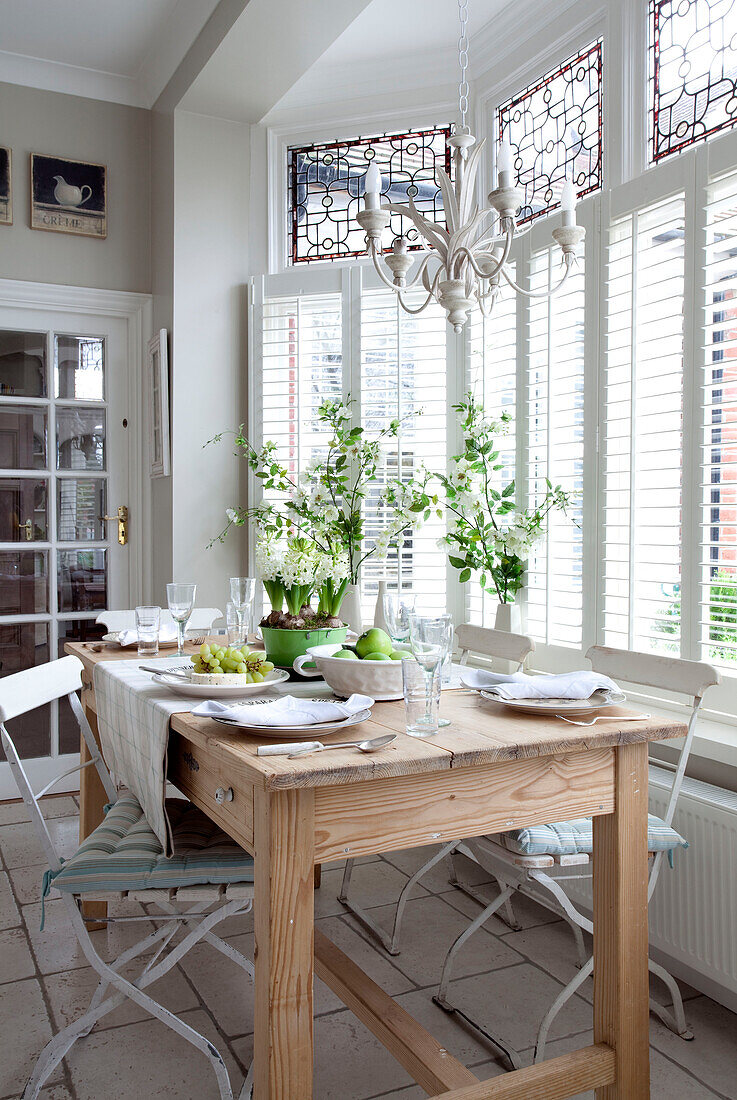 Wooden kitchen table at bay window of Surrey home, England, UK