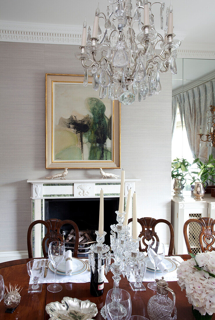 Glass chandelier and artwork in dining room of contemporary London townhouse, England, UK