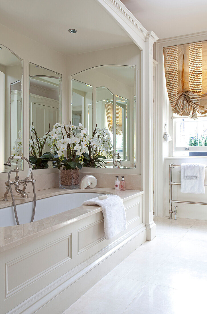 Recessed alcove bath with mirrors and orchid in contemporary London townhouse, England, UK