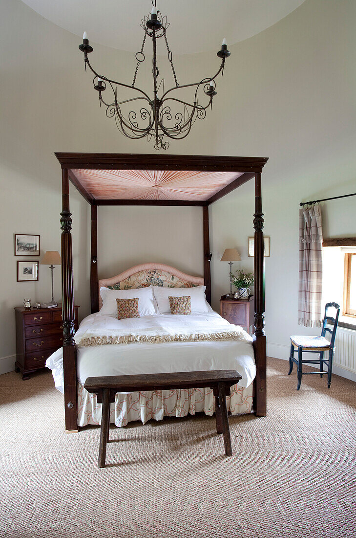 Dark wood four postered bed and stool in Kent farmhouse England UK