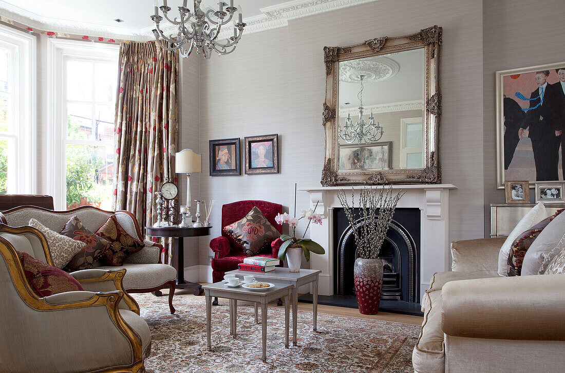 Silver framed mirror on mantlepiece with vintage furniture in London home, UK