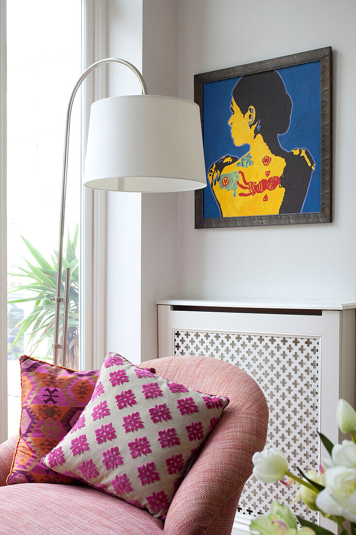 Modern art and floor lamp with double arm chaise in contemporary London living room, UK