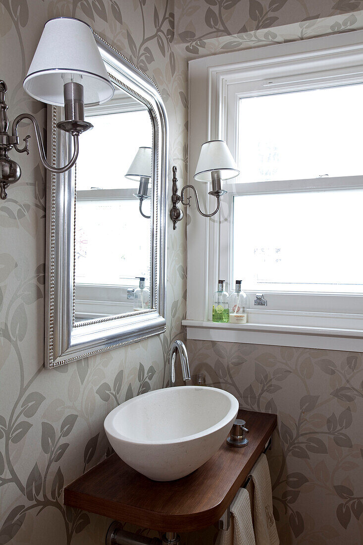 Contemporary wash basin with silver mirror in London cloakroom, UK