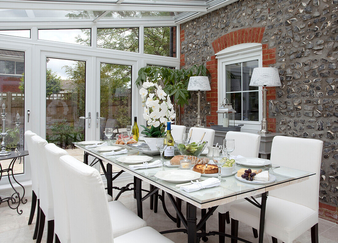 Dining table in conservatory extension of Kent cottage, England, UK